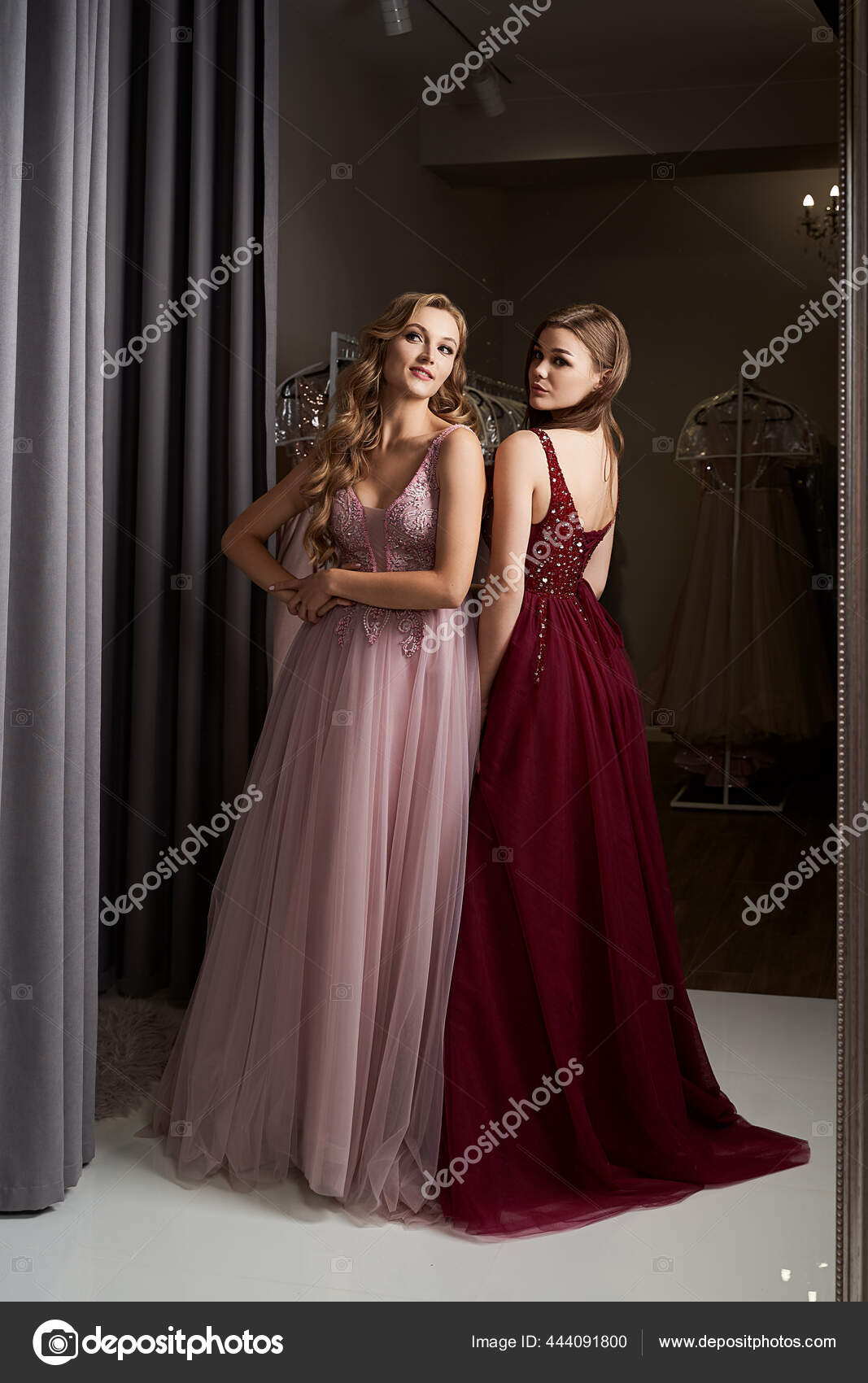 Duas jovens meninas bonitas vestindo um full-length escuro vermelho chiffon  vestido de baile de formatura